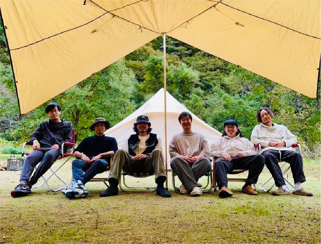 テントの下に座るメンバー